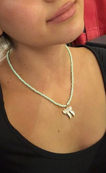 Tel Aviv Chaï necklace: pistachio-green seed beads with a gold pavé chai pendant