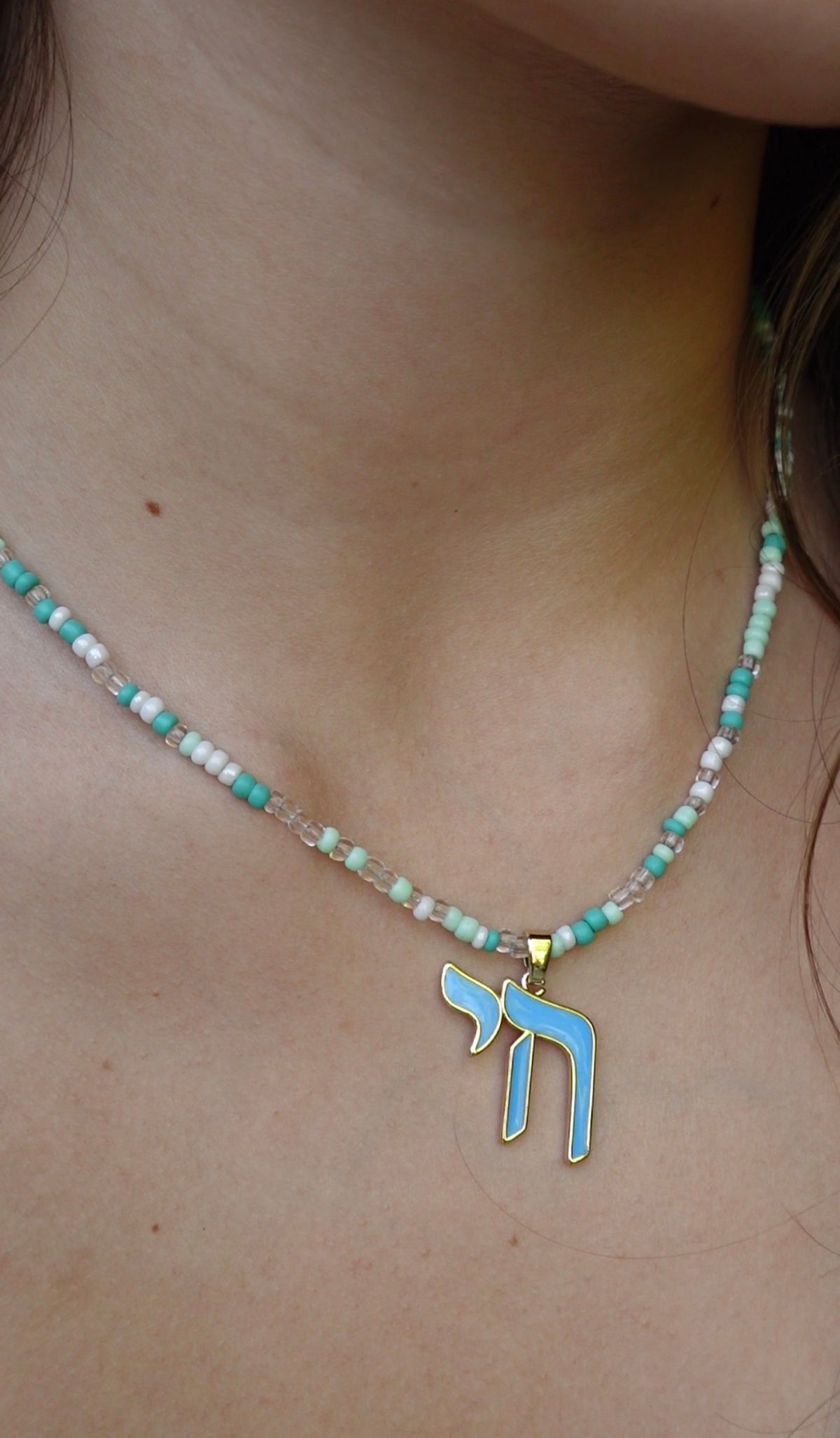 The Hädera Necklace: aqua, mint and white seed beads with a baby-blue enamel chai pendant
