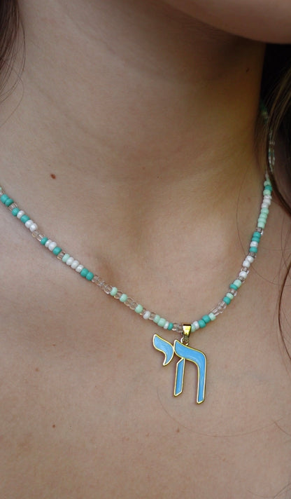 The Hädera Necklace: aqua, mint and white seed beads with a baby-blue enamel chai pendant