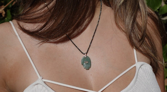 The Jërusalem Necklace: a green stone hamsa pendant on fine faceted dark beads