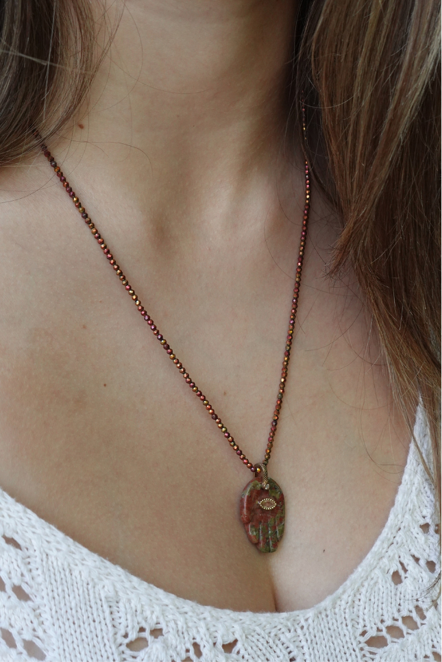 The Rëd Sea Necklace: a red and green mottled stone hamsa on fine copper-toned faceted beads